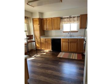 Well-lit kitchen with wooden cabinets, black appliances, and wood-style flooring at 9724 W Euclid Dr, Littleton, CO 80123