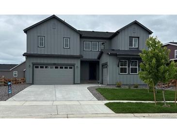 Stylish two-story gray home featuring a two-car garage, concrete driveway, and neatly manicured lawn at 1825 Morgan Dr, Erie, CO 80516