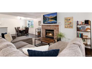Inviting living room featuring a fireplace and an adjacent dining area, perfect for relaxing and entertaining at 1825 S Pitkin Cir # 10, Aurora, CO 80017
