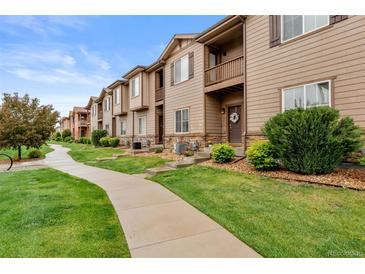 Charming townhome with wood siding, stone accents, small balconies, and landscaped front yard at 1518 Sepia Ave, Longmont, CO 80501