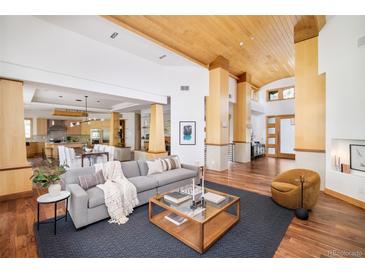 Bright, open-concept living room with wood floors, modern furnishings, and easy access to the kitchen and entry at 1070 Cypress Way, Castle Rock, CO 80108