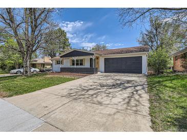 Charming ranch home featuring a two-car garage and a well-maintained front yard with mature trees and a long driveway at 130 S Eaton St, Lakewood, CO 80226