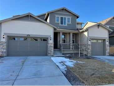 Inviting home featuring a three car garage, covered porch and stone accents at 2598 Knobbie Cir, Castle Rock, CO 80109