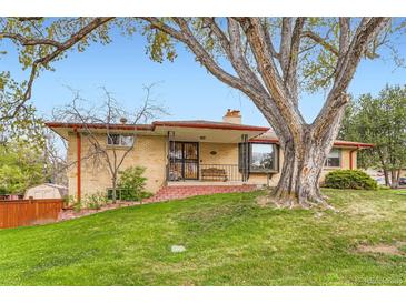 Charming brick home featuring a covered porch and mature landscaping with a large shade tree at 3906 Hoyt Ct, Wheat Ridge, CO 80033
