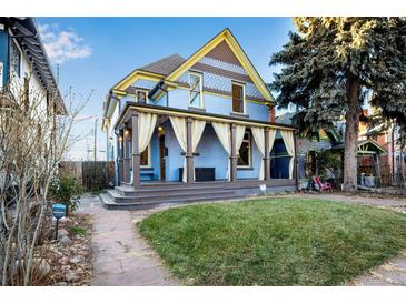 Charming two-story home with a wrap-around porch and well-manicured lawn at 2431 N Ogden St, Denver, CO 80205