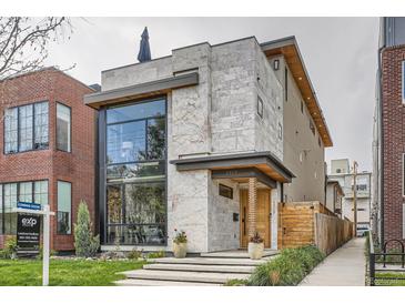 Modern home featuring a light stone facade, a large black-framed window and professional landscaping at 1717 Irving St, Denver, CO 80204