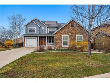 Charming two-story home boasts stone accents, solar panels, and a well-manicured front yard at 13686 Dexter St, Thornton, CO 80602