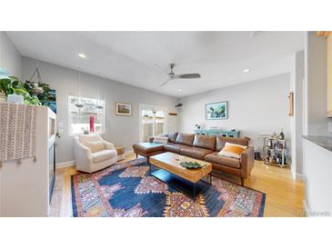 Cozy living room featuring a brown leather sectional sofa, a ceiling fan, and a decorative rug at 1960 S Sherman St, Denver, CO 80210