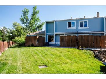 Expansive backyard featuring a lush lawn and privacy fence, perfect for outdoor activities at 7933 Chase Cir # 182, Arvada, CO 80003