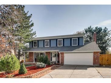 Charming two-story home with blue siding, brick accents, a well-manicured lawn, and a spacious two car garage at 9926 W Nova Pl, Littleton, CO 80127