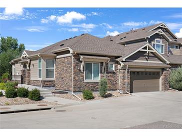 Charming home featuring a stone and siding exterior, well-manicured landscaping, and an attached two-car garage at 14916 E Crestridge Pl, Centennial, CO 80015