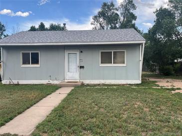 Charming single-story home with gray siding, a well-maintained yard, and a concrete walkway leading to the front door at 804 S 1St Ave, Brighton, CO 80601