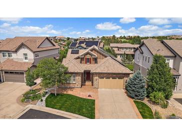 Stunning single-Gathering home boasts mature trees, brick accents and a manicured lawn at 10632 Star Thistle Ct, Highlands Ranch, CO 80126