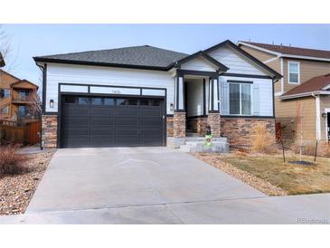 Charming single-Gathering home with stone accents, dark trim, and a two-car garage at 7470 Blue Water Ln, Castle Rock, CO 80108