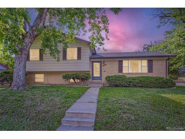 Charming exterior of a two-story home with well-maintained lawn and mature tree at 11797 Keough Dr, Northglenn, CO 80233