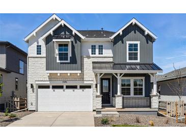 Charming two-story home featuring stone accents, dark gray siding, a black metal roof, and well-manicured landscaping at 7291 Prairie Sage Pl, Littleton, CO 80125