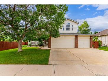 Charming two-story home with a well-maintained lawn and a spacious three-car garage at 12825 Forest Way, Thornton, CO 80241
