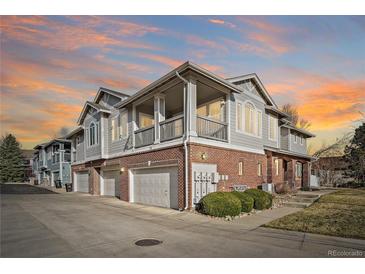 Multi-level townhome showcasing a mix of brick and siding, a private balcony, and attached garage bays at 74 Whitehaven Cir, Highlands Ranch, CO 80129