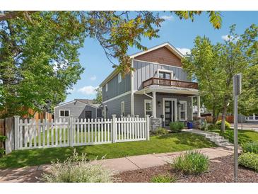 Charming two-story home with a balcony, gray siding, a white picket fence and well maintained landscaping at 4603 W 33Rd Ave, Denver, CO 80212