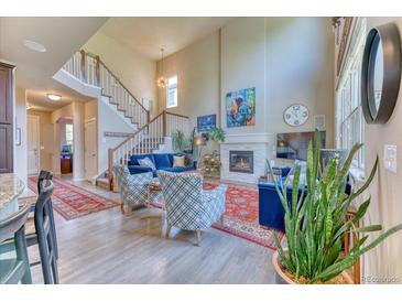 Bright living room features a fireplace, high ceilings, large windows and elegant decor at 2347 S Loveland St, Lakewood, CO 80228