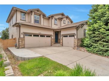 Beautiful two-story home featuring a three-car garage, and neutral toned facade at 10695 Wynspire Rd, Highlands Ranch, CO 80130