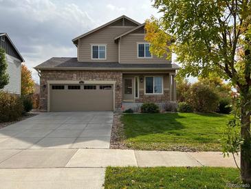 Two-story house with stone accents, two-car garage, and well-maintained lawn at 25934 E Maple Dr, Aurora, CO 80018