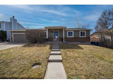 Charming single-story home featuring a brick facade, well-manicured lawn, and inviting front entrance at 17934 E Purdue Pl, Aurora, CO 80013