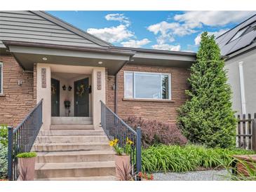Charming brick home featuring a covered entryway, dual front doors, and professionally landscaped yard at 2539 N York St, Denver, CO 80205