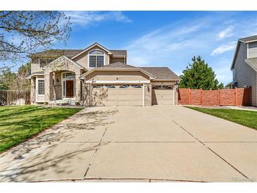 Charming two-story home with a three-car garage and well-maintained front lawn and a brick and siding exterior at 9411 La Quinta Way, Lone Tree, CO 80124