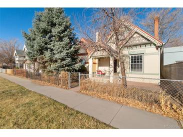 Charming single-Gathering home featuring unique architectural details, a front porch, and well-maintained landscaping at 3135 California St, Denver, CO 80205