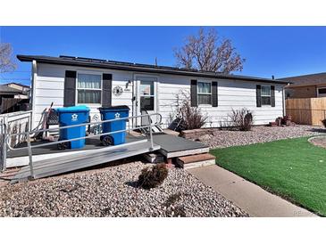 Charming single-story home featuring a ramp to the front door and low-maintenance landscaping at 6060 Locust St, Commerce City, CO 80022
