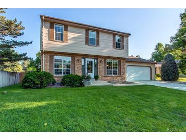 Charming two-story home featuring a well-manicured lawn and a classic brick and siding facade at 8538 W Glasgow Pl, Littleton, CO 80128