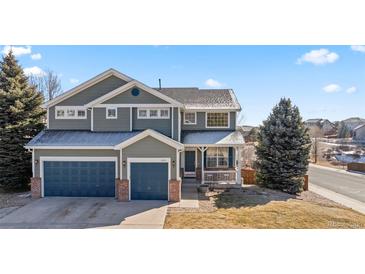 Charming two-story home with well-maintained landscaping, three car garage, and inviting front porch at 1929 Baguette Dr, Castle Rock, CO 80108