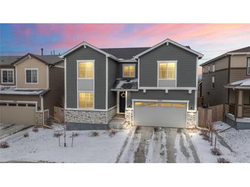 Charming two-story home featuring gray siding, stone accents, and a well-manicured front yard at 5088 S Quail St, Littleton, CO 80127