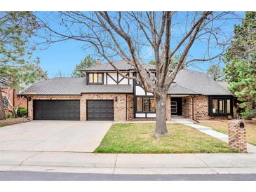 Charming exterior view of a brick home with a large front yard and three-car garage at 4853 S Crystal St, Aurora, CO 80015