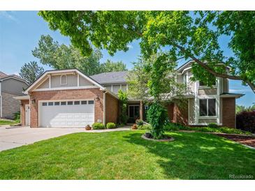 Charming two-story home featuring a well-manicured lawn and a classic brick and siding exterior at 4161 W Lake Cir, Littleton, CO 80123