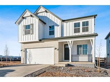 Charming two-story home showcasing white siding, brick accents, and a well-manicured front yard at 8950 Whiteclover St, Littleton, CO 80125