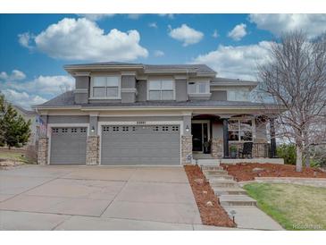 Charming two-story home featuring a three-car garage and a landscaped front yard under a cloudy sky at 22921 E Euclid Cir, Aurora, CO 80016
