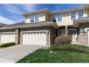 Charming townhome exterior with a stone-accented garage, front yard landscaping, and neutral color scheme at 3000 E 112 Ave # 102, Northglenn, CO 80233
