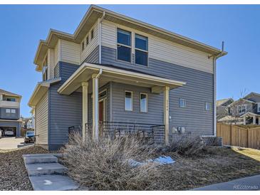 Inviting two-story home featuring a covered porch and a blend of gray and beige siding at 3744 Celestial Ave, Castle Rock, CO 80109