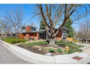 Striking brick home with modern architecture, mature landscaping, and a welcoming front yard at 3895 Chimayo Rd, Littleton, CO 80123