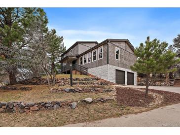 Two story home on a hill with stone accents, multiple windows, and a two-car garage at 8165 Tempest Ridge Way, Parker, CO 80134