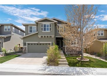 Charming two-story home with stone accents, a manicured lawn, and a two car garage at 5400 Heatherton Ln, Highlands Ranch, CO 80130