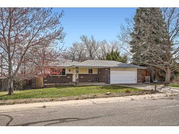 Charming single-story brick home with a well-manicured lawn and attached two-car garage on a sunny day at 798 Xenophon St, Lakewood, CO 80401