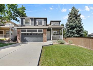Charming two-story home with a well-maintained lawn, attached garage, and inviting front porch at 10295 Ravenswood Ln, Highlands Ranch, CO 80130