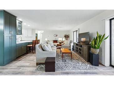 Bright living room features modern décor and an open layout connecting to the kitchen at 13850 E Marina Dr # 606, Aurora, CO 80014