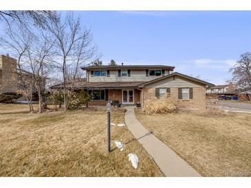 Charming two-story brick home with manicured lawn and inviting walkway at 6323 W Rowland Cir, Littleton, CO 80128