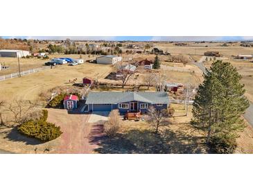 Charming home featuring mature landscaping, a cozy front porch and gravel driveway, with multiple outbuildings at 200 Bothun Rd, Berthoud, CO 80513