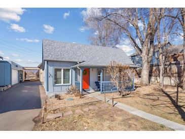 Charming blue home with a covered porch and a vibrant orange front door at 103 Sunset St # A, Longmont, CO 80501