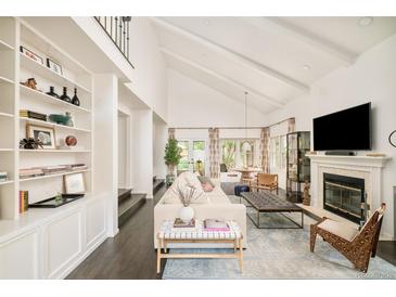 Bright, open living room with vaulted ceilings, built-in shelving, and a fireplace at 40 S Dexter St, Denver, CO 80246